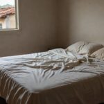 Quarto simples com cama desfeita simbolizando sono excessivo e risco de mobilidade em idosos