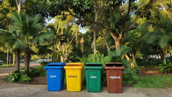 Lixeiras coloridas de reciclagem em praça de Ji-Paraná para descarte correto de lixo.