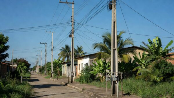 Postes de energia e hidrômetros em rua de Ji-Paraná representando serviços de luz e água
