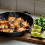Peixe frito crocante em frigideira com limão, técnica para fritura sem odor forte